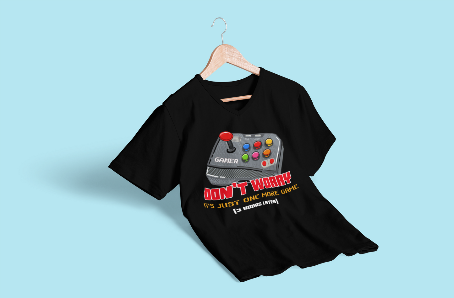 Black "Just One More Game" T-shirt on hanger against a blue background